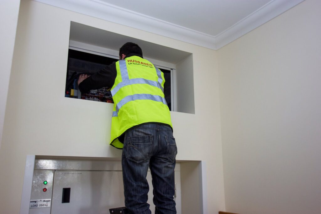 Lift engineer repairing dumb waiter, dumbwaiter maintenance