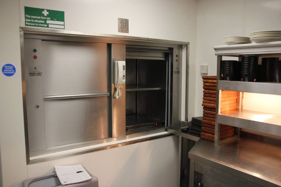 Double decker dumbwaiters are seen side by side in a restaurant and are used to move multiple items between floors. dumbwaiter maintenance