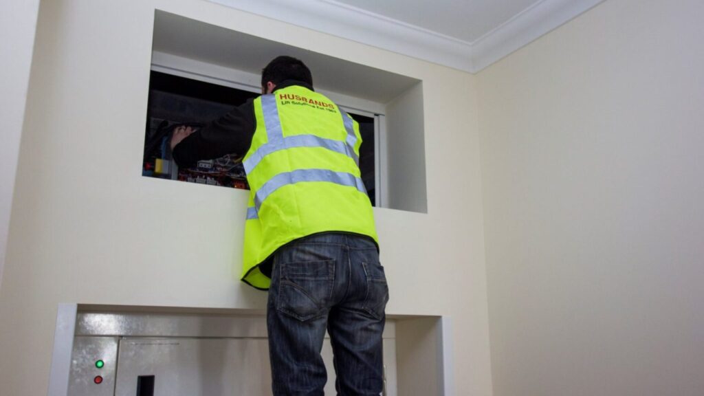 An engineer is servicing a dumbwaiter as part of a dumbwaiter and service lift maintenance and repair contract in the UK, service lift