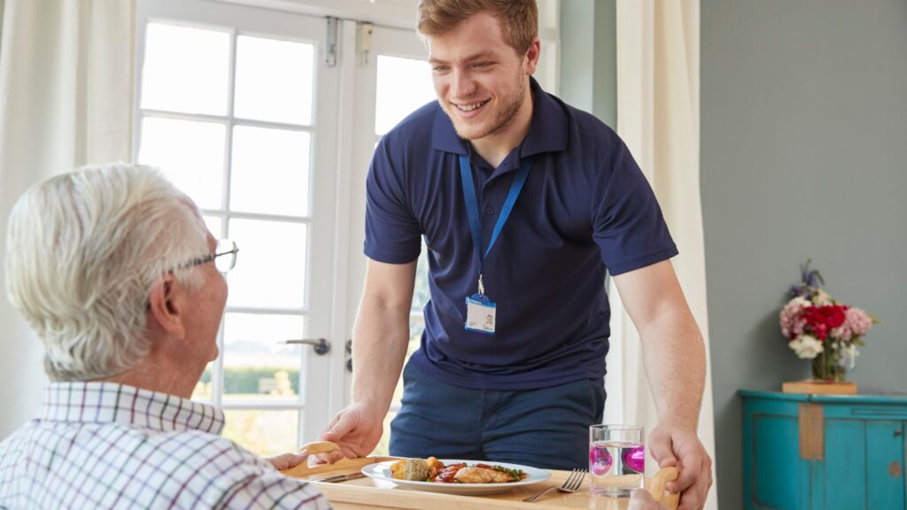a nurse delivers a meal in a care home using a service lift